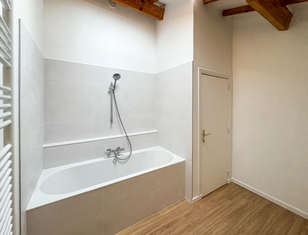 Installation d’une baignoire OBERON et pose de carrelage mural clair dans une salle de bain rénovée à Courzieu (Ouest Lyonnais).